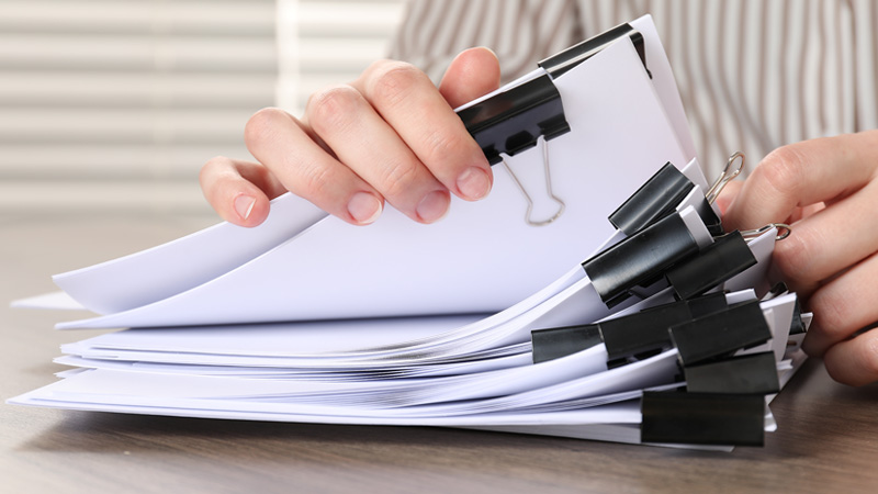 Someone flipping through multiple paper reports.