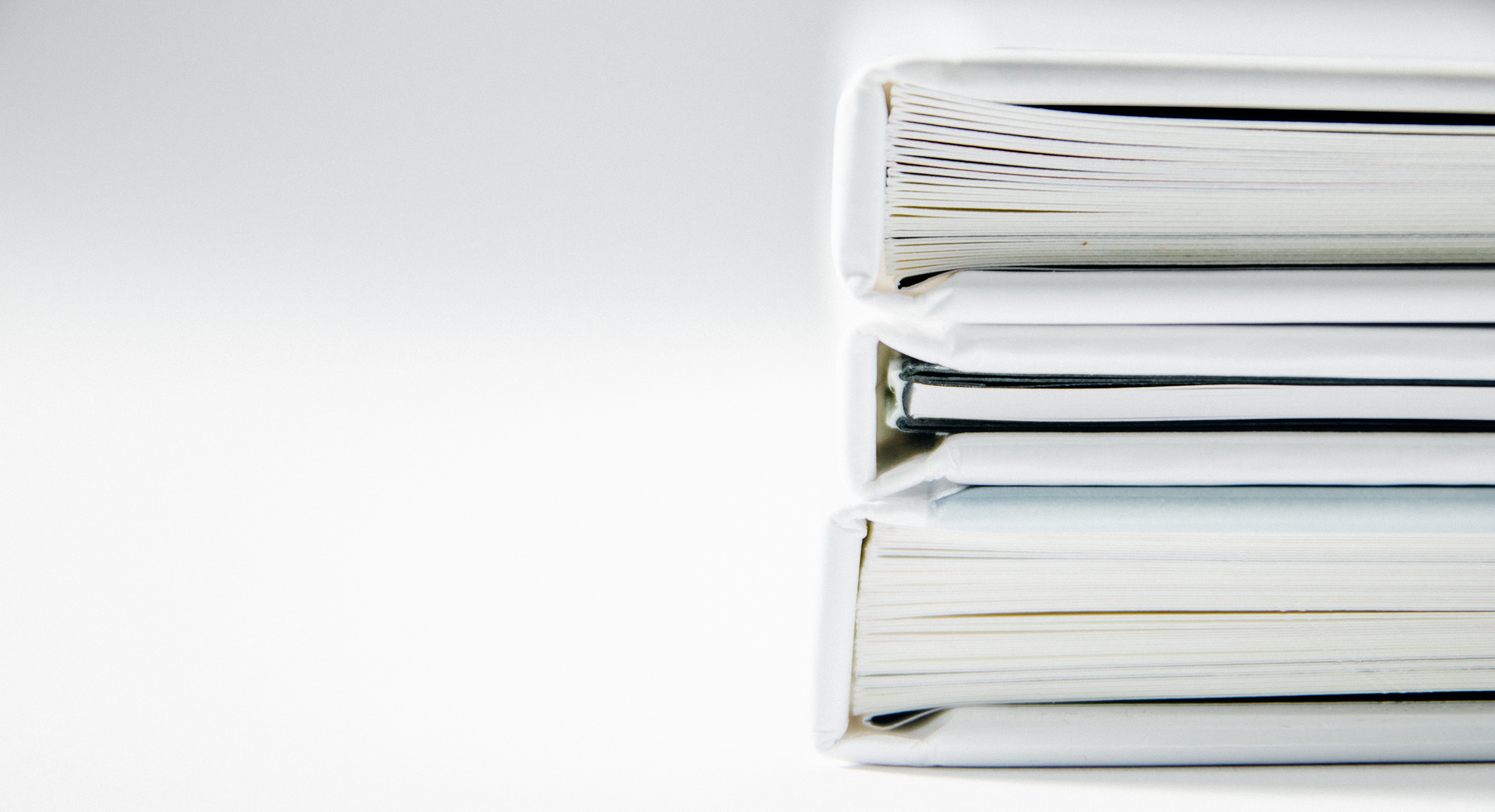 Stack of three binders with paper inside the binders