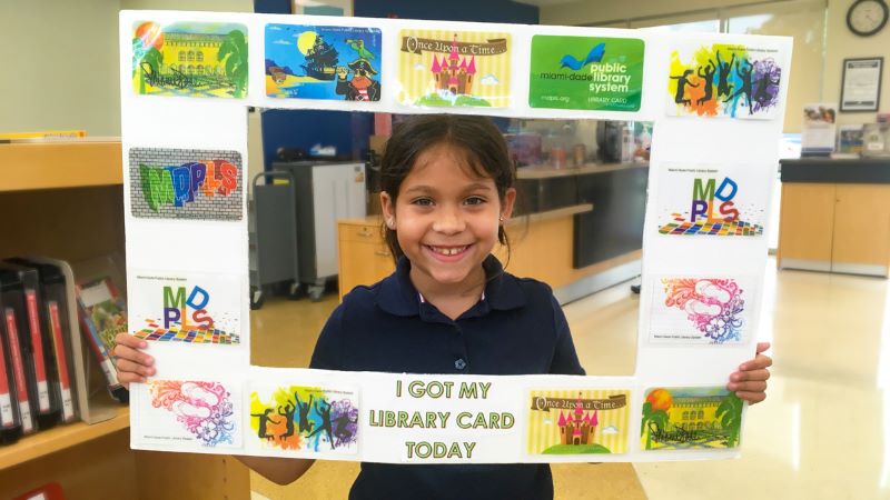 Girl holding a library card picture frame