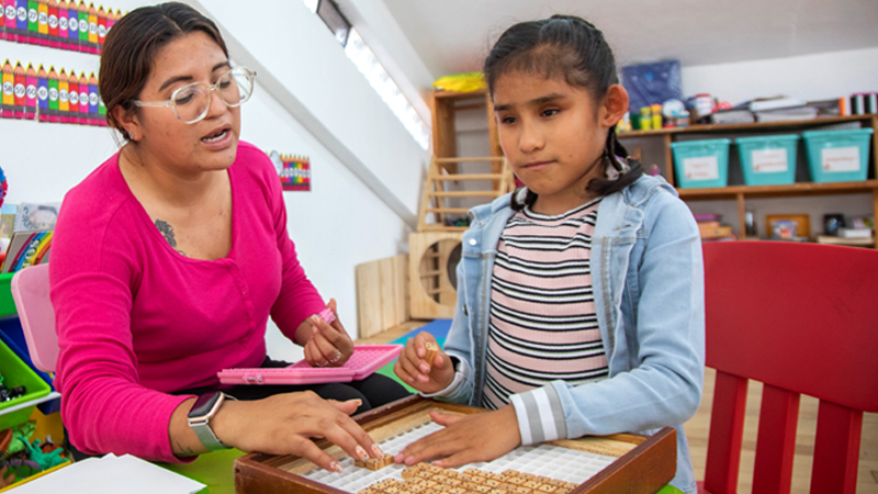 woman and child working on sensory board 