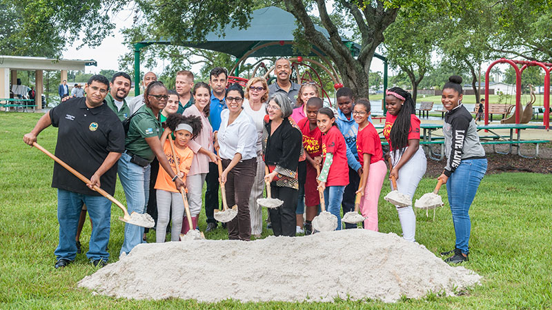 Kids and adults about to shovel dirt at a park groundbreaking